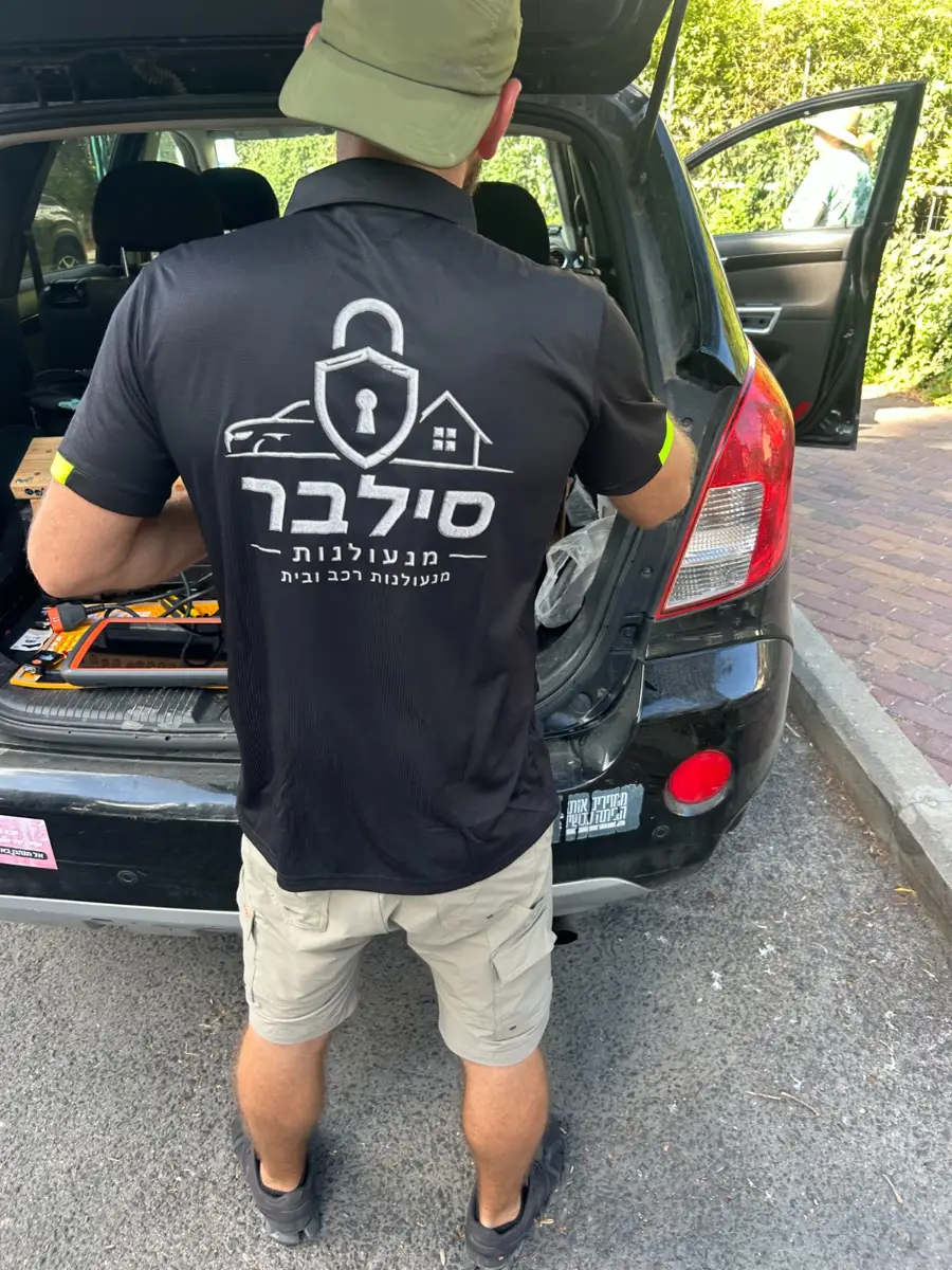 מנעולן של סילבר מנעולנות בחולצה ממותגת עובד מרכב השירות הנייד עם ציוד קידוד מפתחות בחיפה